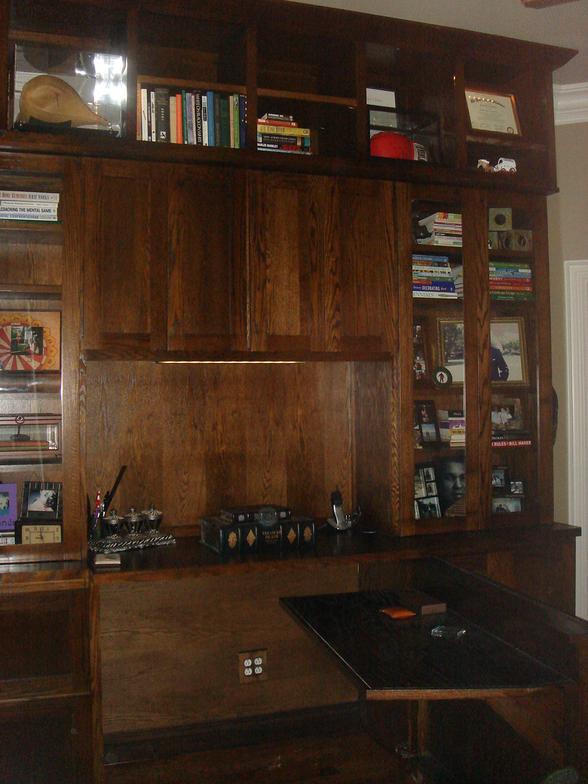 This custom designed bookcase has a hidden desk that saves space and hides clutter