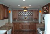The blank wall at the end of this galley kitchen received additional cabinetry for storage and food prep. 