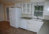 French doors to the backyard, tiled floor, and glass front cabinets update this older home.