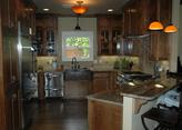 This new kitchen uses custom cabinetry, copper sink, professional grade appliances, and detailed tile work.
